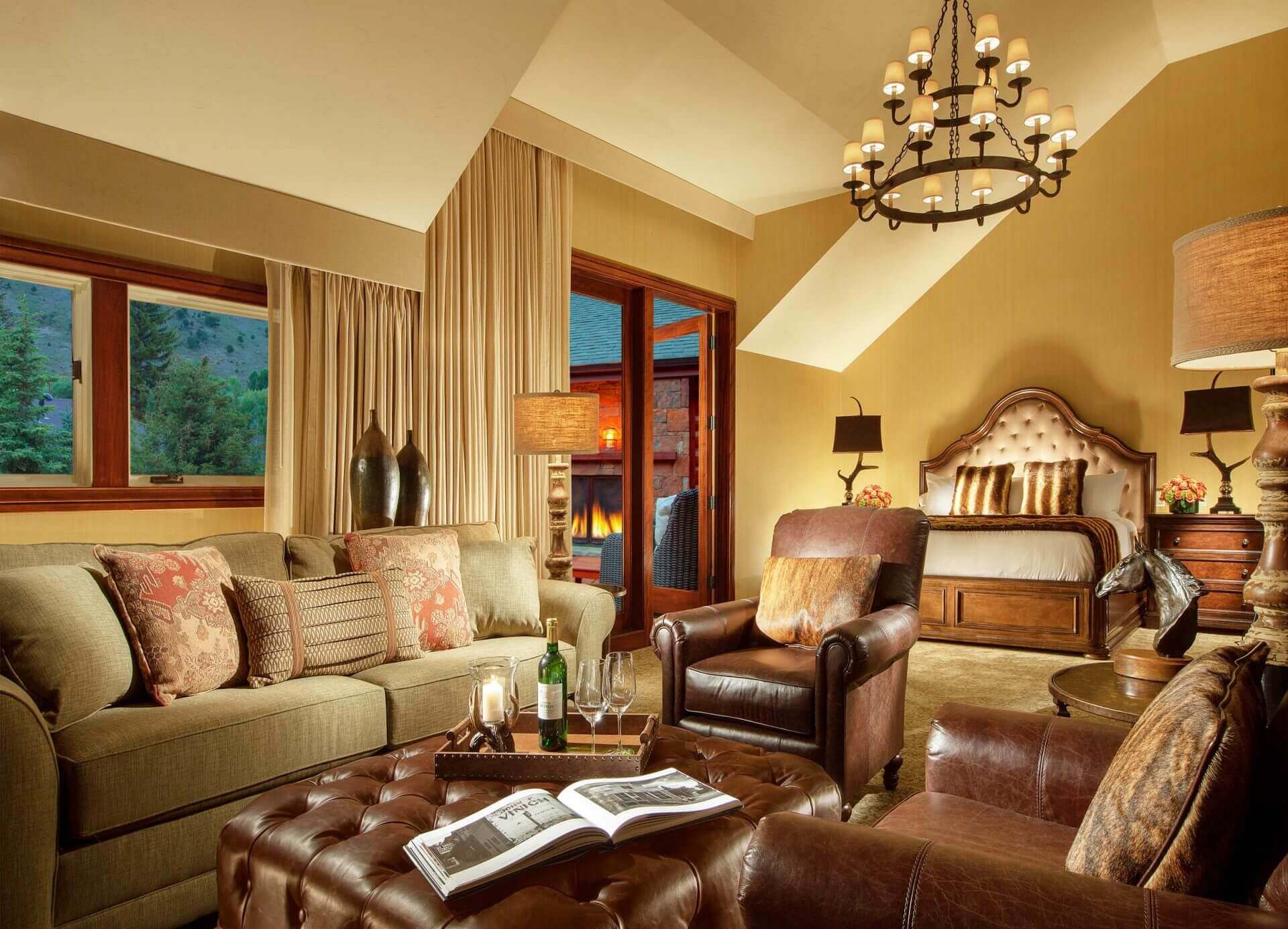 luxury hotel room with leather couches, king sized bed and outdoor fireplace
