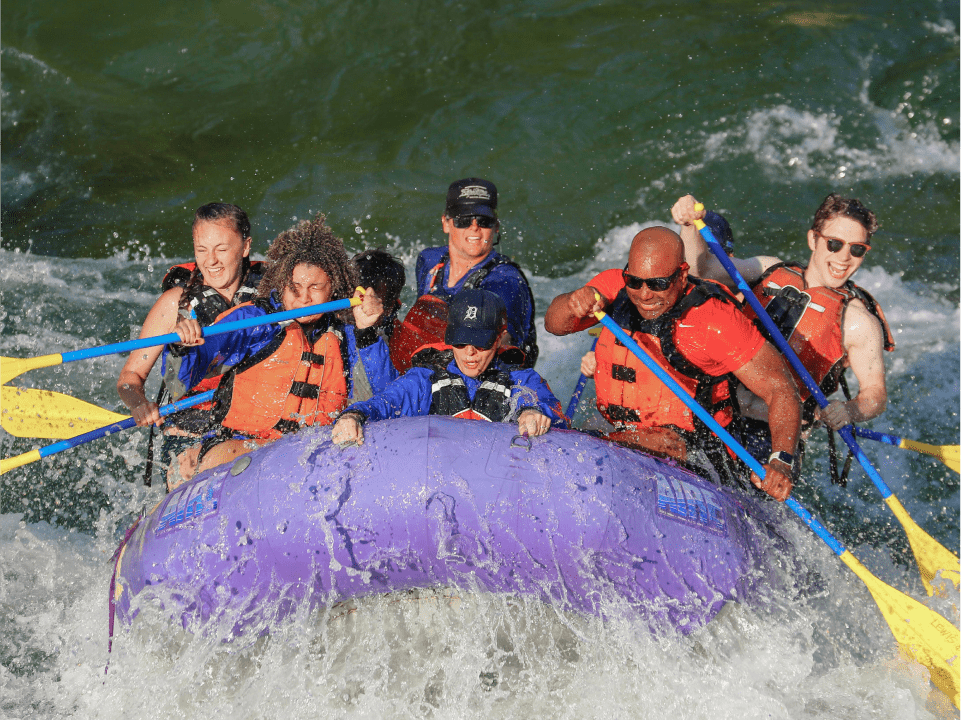people on a raft with their paddles white water rafting