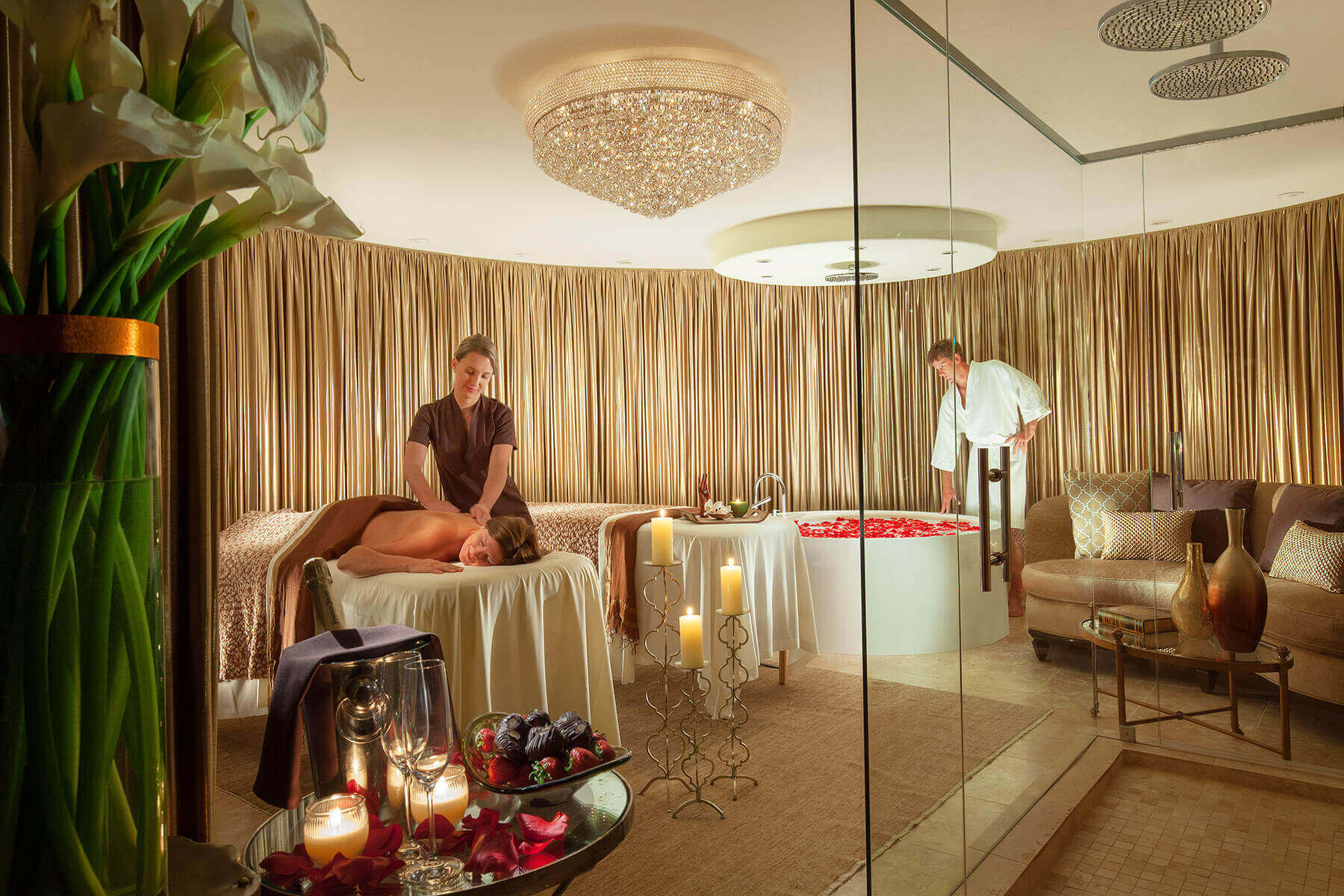 spa room with female getting massage and male filling bath tub