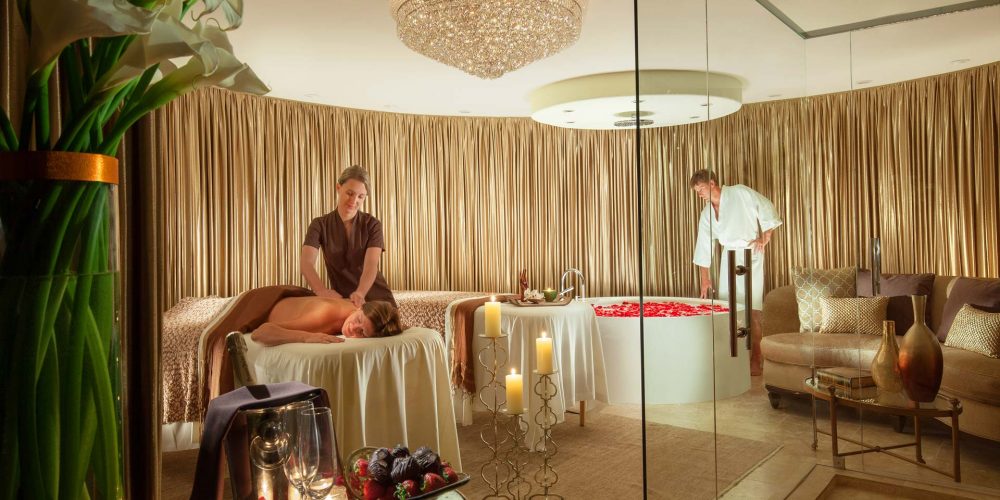 spa package - spa room with female getting massage and male filling bath tub