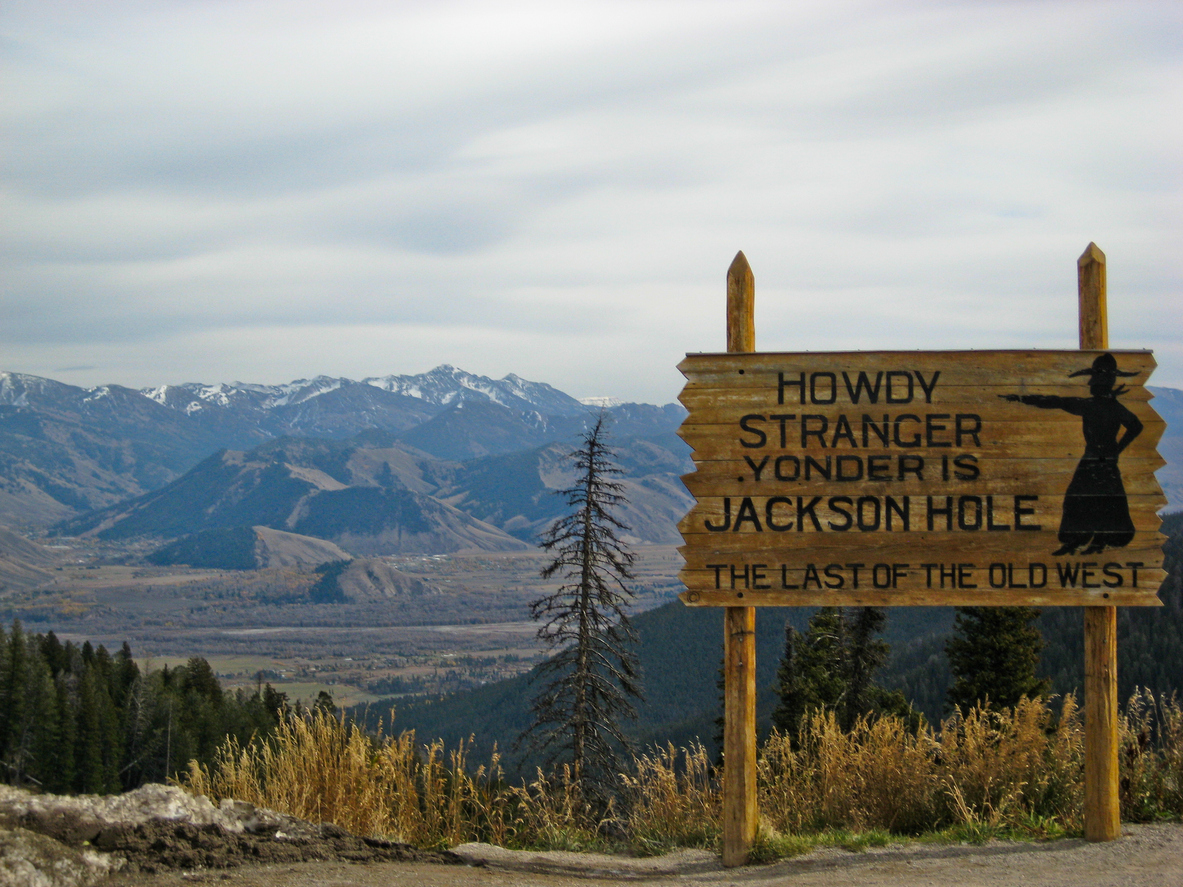 Wood sign that reads "Howdy Stranger, Yonder is Jackson Hole, The Last of the Old West"