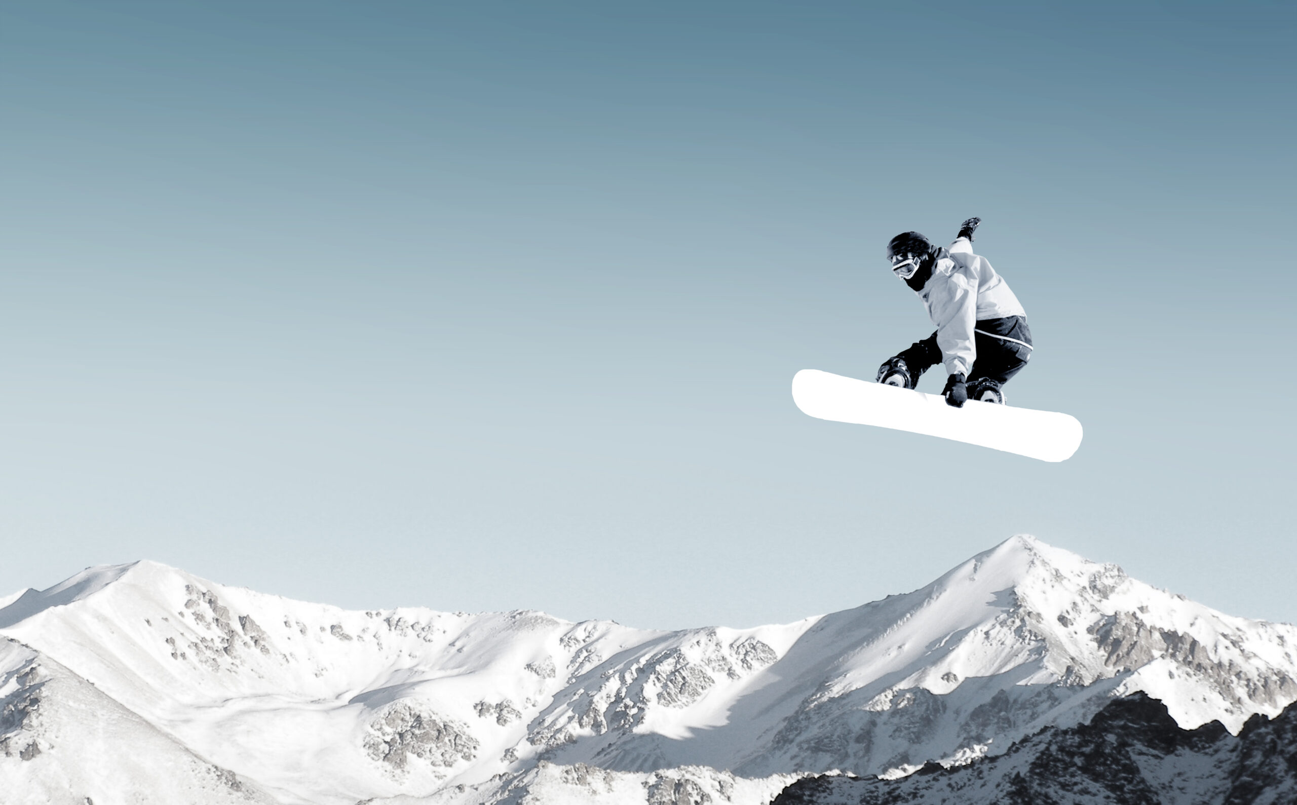 Snowboarder making high jump in clear blue sky