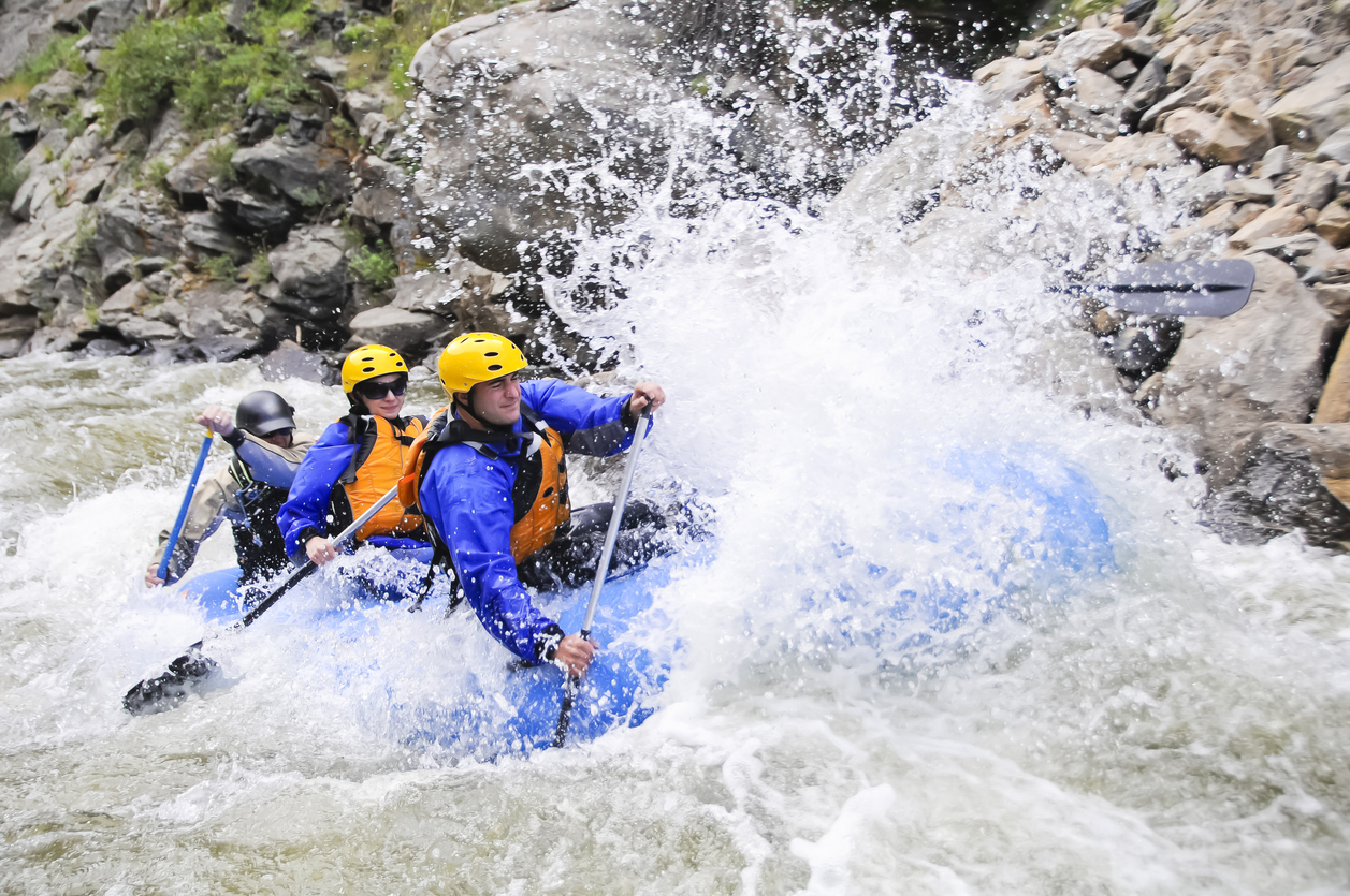 People on a whitewater rafting trip in a raft on the rapids