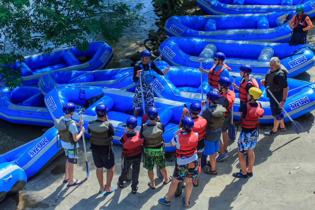 people planning for a whitewater rafting trip with guides and rafts
