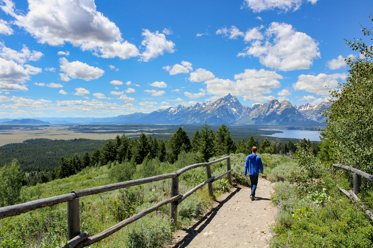Boy hiking in Jackson Hole in the Summer with lake and mountain